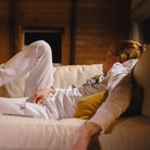 Paula lounging in white track suit on white couch